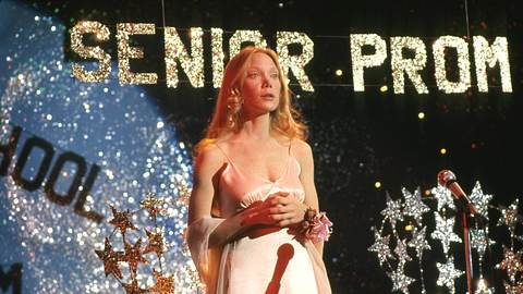 Man sieht Sissy Spacek als titelgebender Charakter aus dem Film „Carrie“ aus dem Jahr 1976 von Brian De Palma. Sie trägt ein rosa Abschlusskleid auf und ist auf einem Abschlussball. Im Hintergrund glänzt der Schriftzug „Senior Prom“.  - Foto: IMAGO / Cinema Publishers Collection
