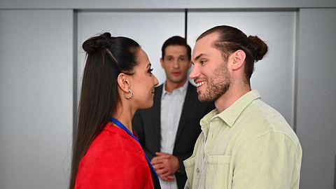 Charlie und Milan lächeln sich glücklich an, im Hintergrund ist Deniz zu sehen. - Foto: RTL / Julia Feldhagen