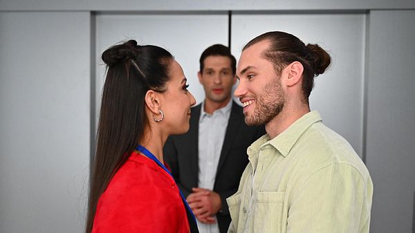 Charlie und Milan lächeln sich glücklich an, im Hintergrund ist Deniz zu sehen. - Foto: RTL / Julia Feldhagen