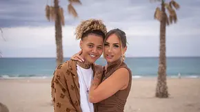 Chika und Carina stehen eng umschlungen vor einem Strand mit Palmen und Meer und schauen in die Kamera. - Foto: RTL / Jonas Mohr Chika und Carina stehen eng umschlungen vor einem Strand mit Palmen und Meer und schauen in die Kamera. - Foto: RTL / Jonas Mohr