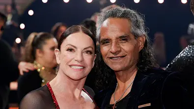 Christine Neubauer im schwarz-roten Kleid und Ehemann José Campos mit langen grauen Haaren und dunklem Sakko lächeln gemeinsam in die Kamera. - Foto: Imago/Future Image Christine Neubauer im schwarz-roten Kleid und Ehemann José Campos mit langen grauen Haaren und dunklem Sakko lächeln gemeinsam in die Kamera. - Foto: Imago/Future Image