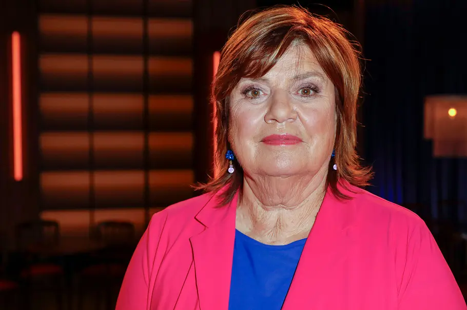 Christine Westermann in eimem blauen T-Shirt mit einem magentafarbenen Blazer blickt direkt in die Kamera.