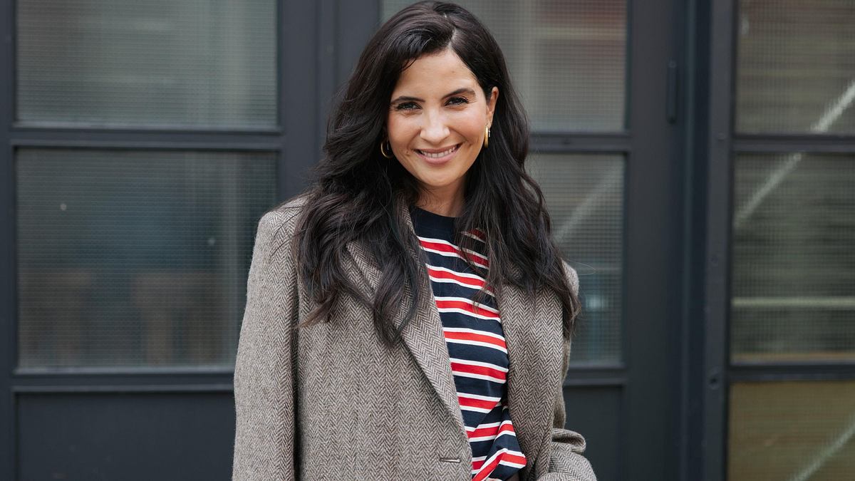 Chryssanthi Kavazi ist zurück bei GZSZ. Chryssanthi Kavazi posiert in grauem Blazer und Jeans.
