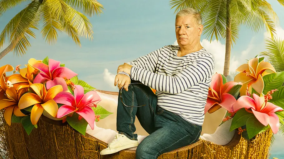 Claude-Oliver Rudolph Ein Mann sitzt auf einer halbierten Kokosnuss an einem tropischen Strand, umgeben von Palmen und bunten Blumen. Im Hintergrund ist das Meer zu sehen, darüber fliegt ein Papagei.