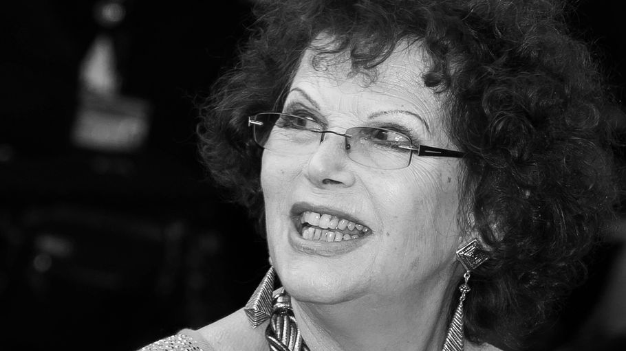 Claudia Cardinale trägt eine Brille und guckt zur Seite.