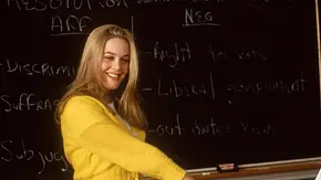 Cher hält vor der ganzen Klasse eine Rede. Hinter ihr ist eine Tafel. - Foto: IMAGO / Everett Collection Cher hält vor der ganzen Klasse eine Rede. Hinter ihr ist eine Tafel. - Foto: IMAGO / Everett Collection