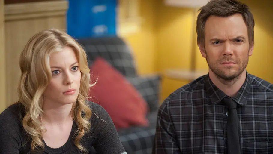 Community Britta Perry und Jeff Winger sitzen mit ernsten Mienen an einem Tisch im Studienraum des Greendale Community College – eine Szene aus der Comedyserie „Community“.
