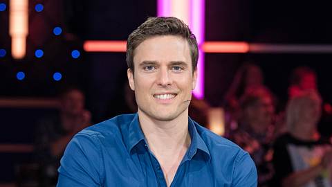 Tagesschau-Sprecher Constantin Schreiber lächelt bei einer Aufzeichnung der Talkshow „Riverboat“ in die Kamera. - Foto:  IMAGO / STAR-MEDIA