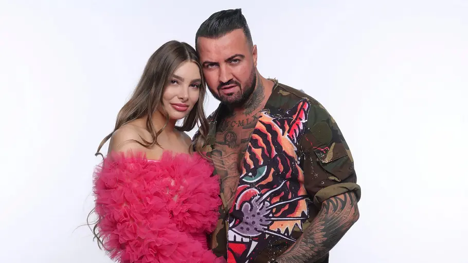 Cosimo Citiolo und Nathalie Gaus. Nathalie Gaus im pinken Rüschenkleid und Cosimo Citiolo im offenen Hemd mit Tigermotiv posieren eng beieinander.