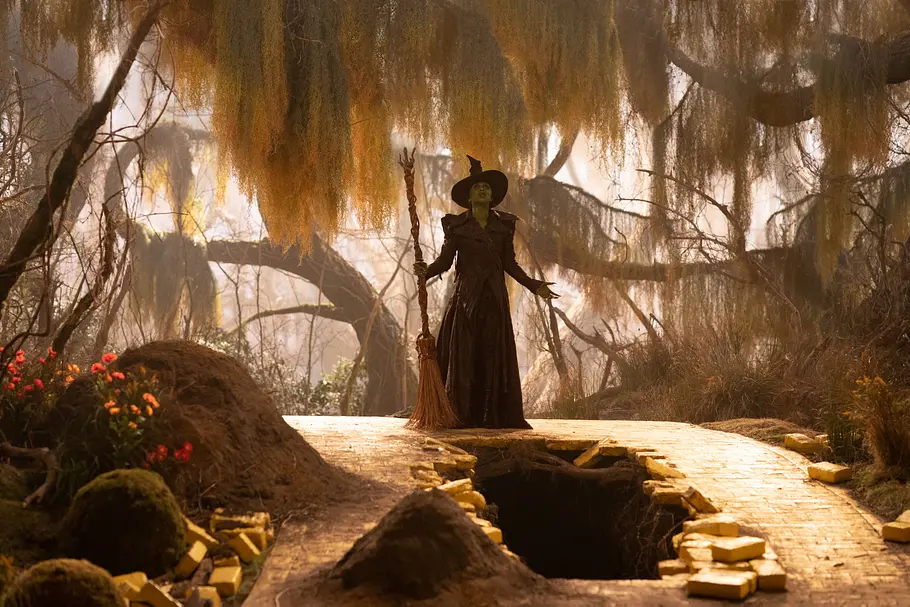 Cynthia Erivo als Elphaba in Wicked 2 Cynthia Erivo als Elphaba steht im mit ihrem Besen im Wald.