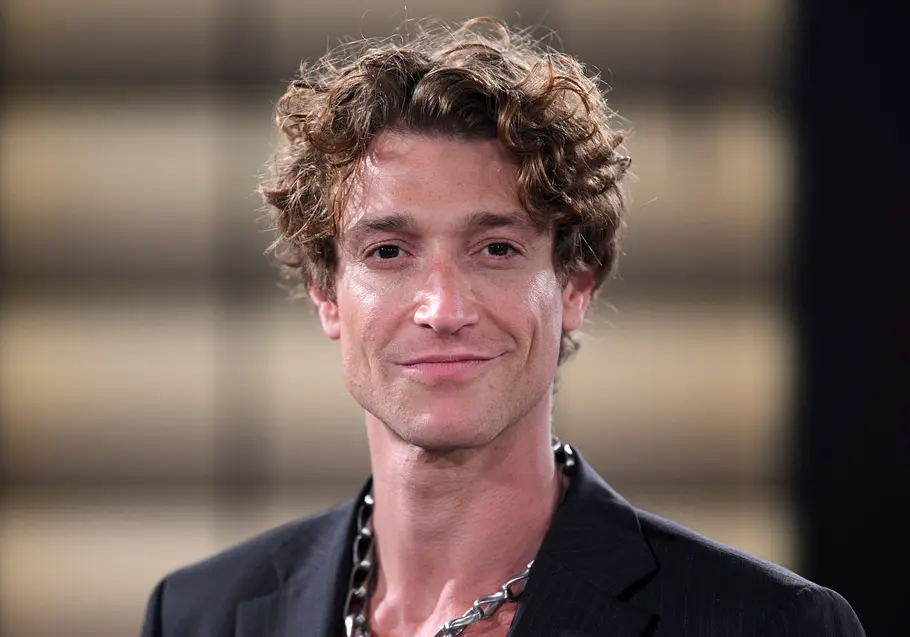 Daniel Donskoy trägt ein dunkles Sakko und lächelt leicht in die Kamera. Der Hintergrund ist unscharf und dezent beleuchtet.