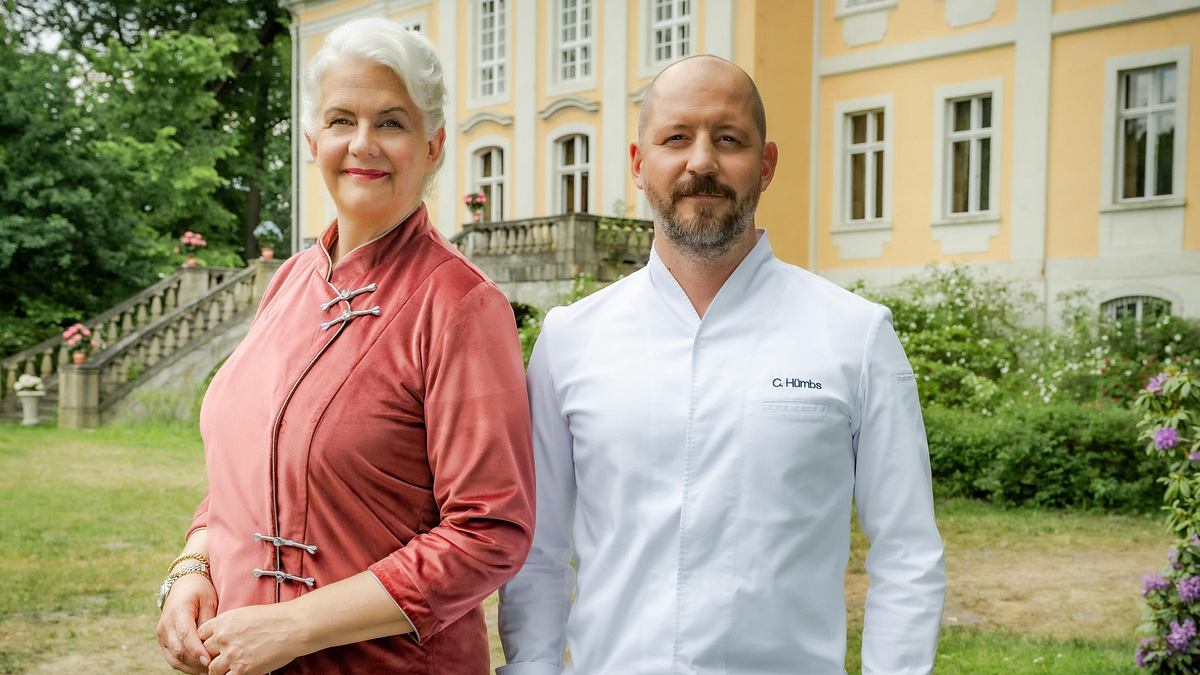  Bettina Schliephake-Burchardt und Christian Hümbs posieren vor einem gelben Schloss für Das große Backen