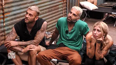 Serkan, Rafi und Bellydah sitzen beim Promi Büßen auf einem Feldbett und lauschen einer Runde der Schande - Foto: Joyn