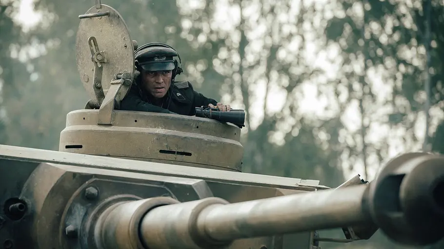 David Schütter in „Der Tiger“ als Leutnant Philip Gerkens: Er sitzt in seinem Panzer und schaut aus der Luke heraus. In der Hand ein Fernglas, der Blick konzentriert nach vorne gerichtet.