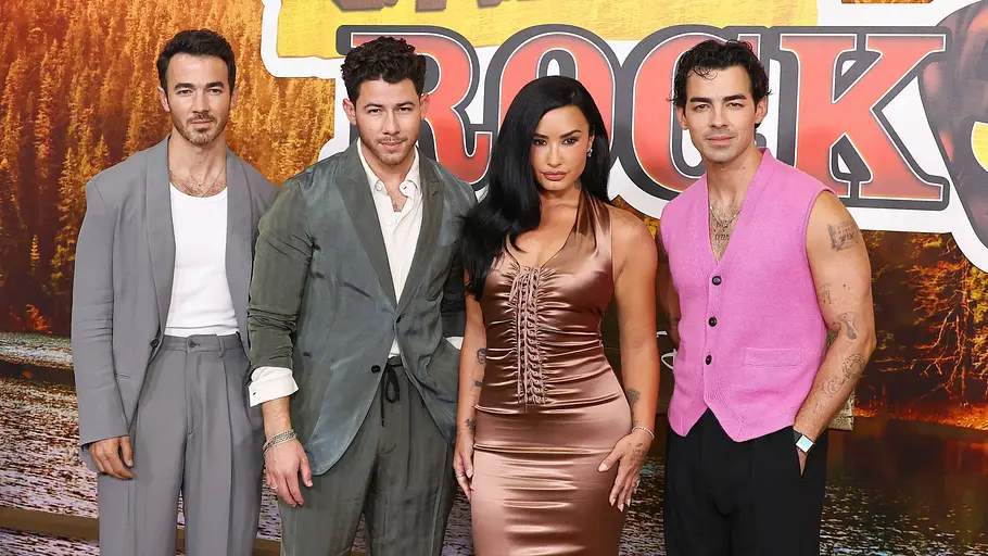 Die Jonas Brothers und Demi Lovato lächeln auf dem Red Carpet „Camp Rock 3“.