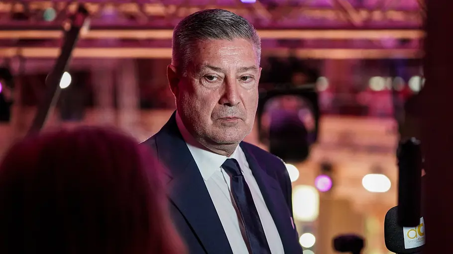 Den Ruf des strengsten „Let's Dance“-Jurors wird Joachim Llambi so schnell nicht los. Joachim Llambi trägt einen dunklen Anzug mit Krawatte vor einer violett beleuchteten Kulisse. Rechts ist ein Mikrofon zu sehen.