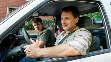 Stefan Vollmer sitzt im Auto neben seinem Schüler im Auto und lächelt - Foto: RTL / Steffen Junghans