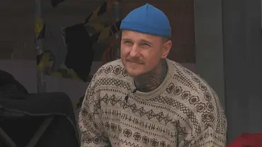 Paco Herb trägt eine blaue Mütze und schaut jemanden außerhalb des Bildes misstrauisch an. - Foto: Joyn