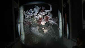 Eine aus mehreren Zombies bestehende Kreatur bricht durch eine Tür und wird von einer Taschenlampe beleuchtet. - Foto: Naughty Dog