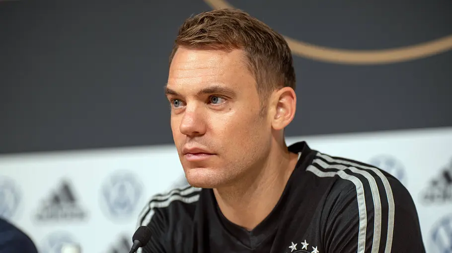 Manuel Neuer sitzt in einer Pressekonferenz und schaut ernst.