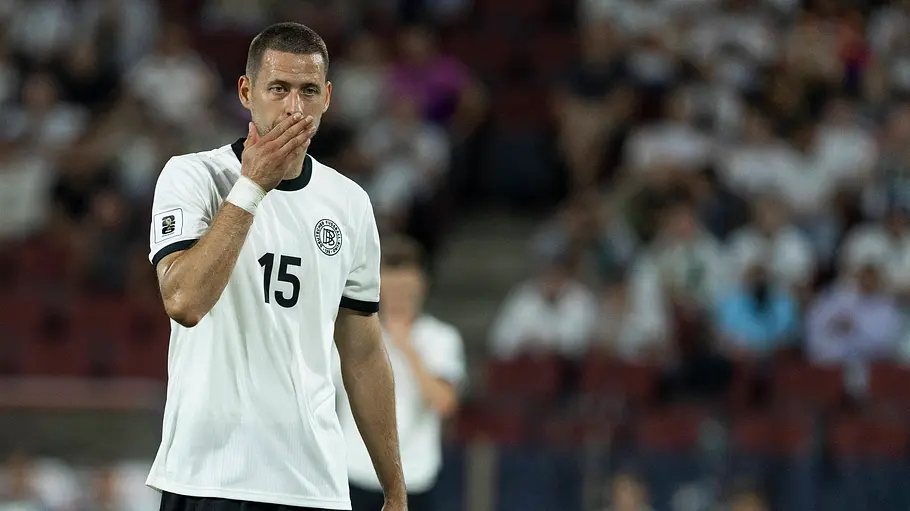 Waldemar Anton steht auf dem Feld und hält sich die Hand vor den Mund