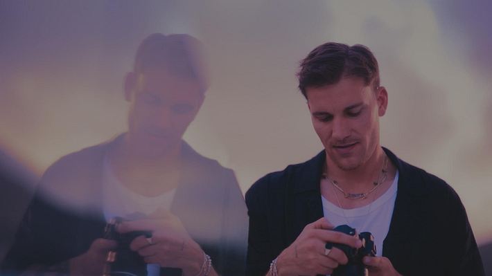 Bachelor Felix Stein schaut nachdenklich auf seine Kamera, links ist sein Spiegelbild zu sehen - Foto: RTL