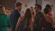 Die Bachelors und die Kandidatinnen stehen bei einer Abendveranstaltung in einem warm beleuchteten Raum zusammen. Sie lachen und unterhalten sich. - Foto: RTL Die Bachelors und die Kandidatinnen stehen bei einer Abendveranstaltung in einem warm beleuchteten Raum zusammen. Sie lachen und unterhalten sich. - Foto: RTL