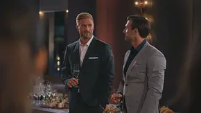 Sebastian und Tim im Anzug stehen bei einem Empfang nebeneinander, halten jeweils ein Glas in der Hand und unterhalten sich. - Foto: RTL