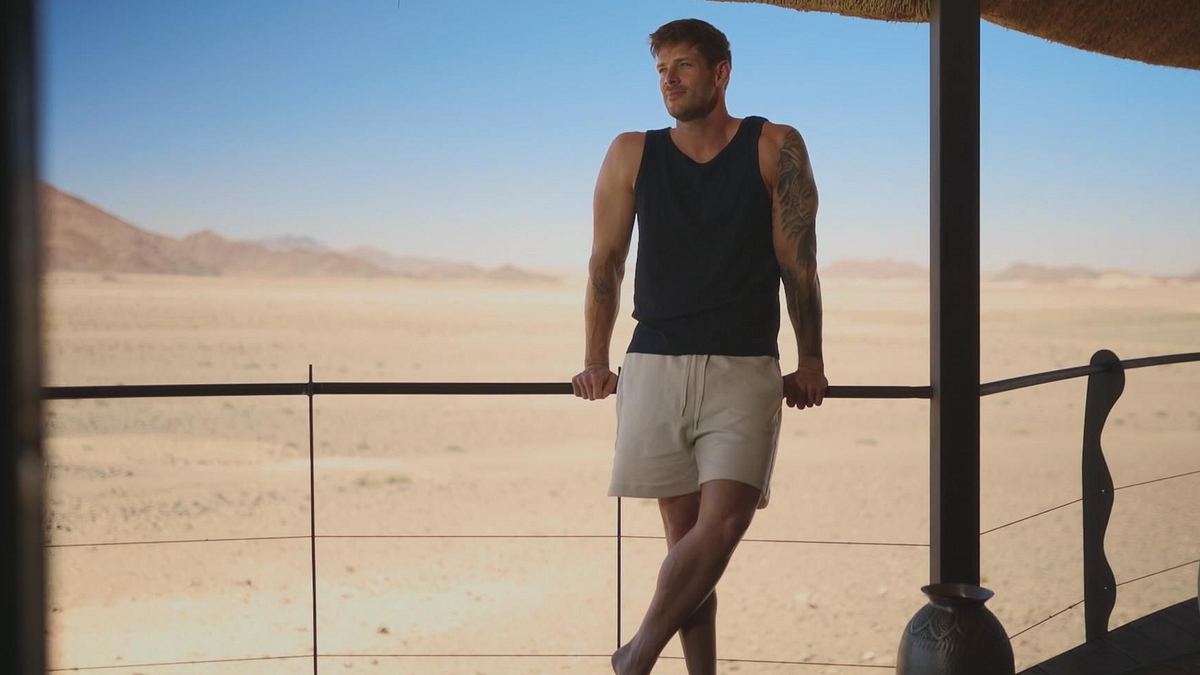 Bachelor Martin Braun posiert an einem Geländer und schaut in die Gerne