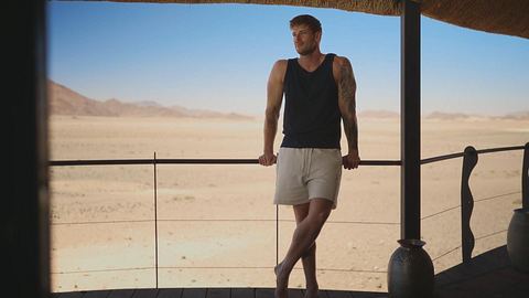 Bachelor Martin Braun posiert an einem Geländer und schaut in die Gerne - Foto: RTL