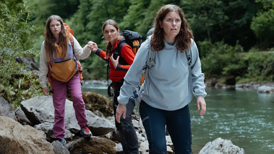 „Die Bergretter“ Staffel 18: Nina sucht mit Mareike und Svea nach Jonas Nina, Mareike Neuer und Svea Neuer suchen am Flussufer angespannt nach Jonas.
