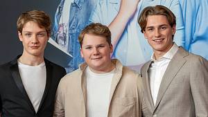 Levi Brandl, Nevio Wendt und Julius Weckauf stehen nebeneinander vor der Fotowand der Premiere der drei Fragezeichen und lächeln in die Kamera. - Foto: IMAGO / Future Image