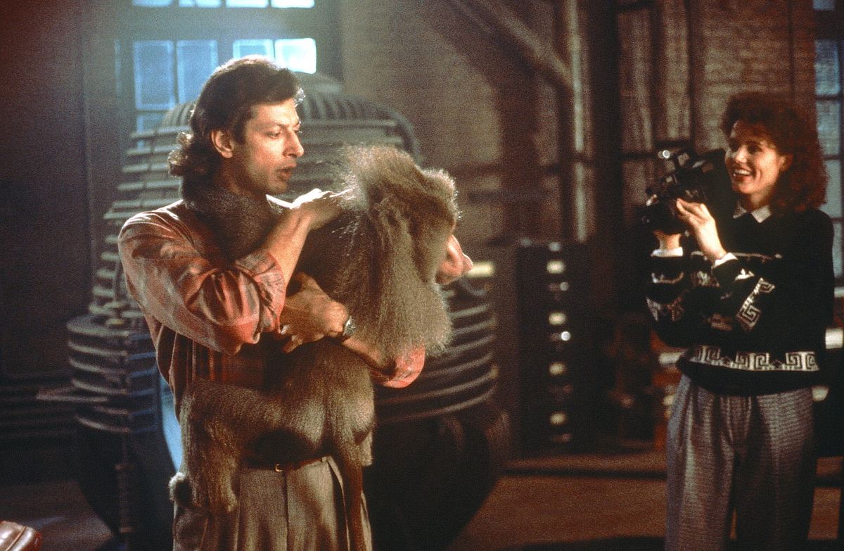 Die Fliege Jeff Goldblum hält einen Affen und Geena Davis filmt ihn dabei.