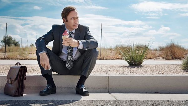 Bob Odenkirk sitzt als Jimmy McGill mit einem Eis auf einem Bürgersteig. - Foto: TMDB