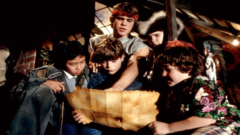 Die Goonies schauen sich eine geheimnisvolle Schatzkarte an. - Foto: IMAGO / Everett Collection