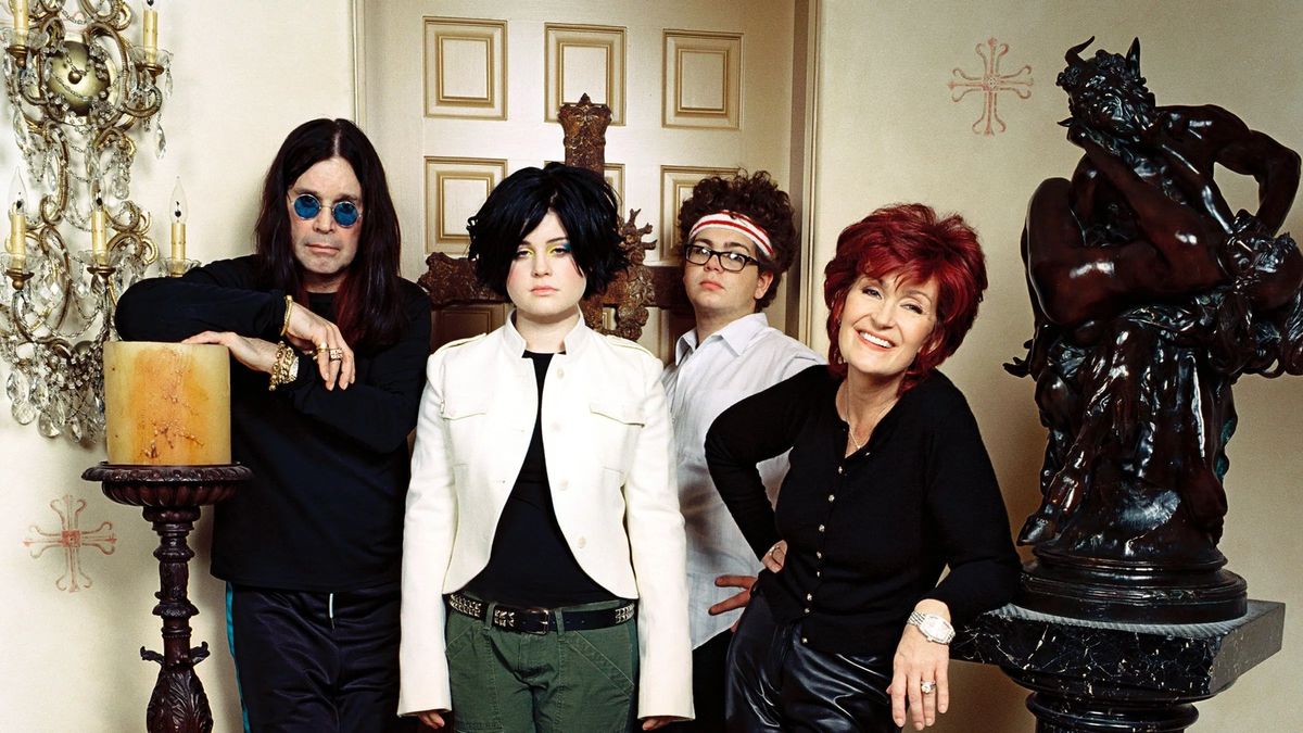 Ozzy, Kelly, Jack und Sharon Osbourne posieren zwischen einer dicken Kerze und einer schwarzen Statue.