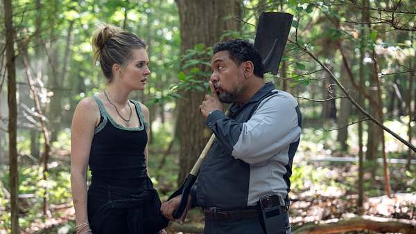 Devon schaut Jose fragend an. Dieser hält mit der rechten Hand eine Schaufel und hält den Zeigefinger der linken Hand vor seine Lippen. - Foto: MACALL POLAY/NETFLIX