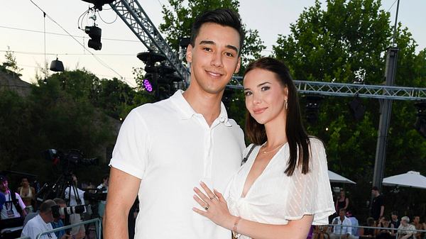 Diego Pooth und Freundin Louisa Buescher stehen nebeneinander und lächeln in die Kamera. Louisa hält Diegos Bauch. - Foto: IMAGO / BREUEL-BILD