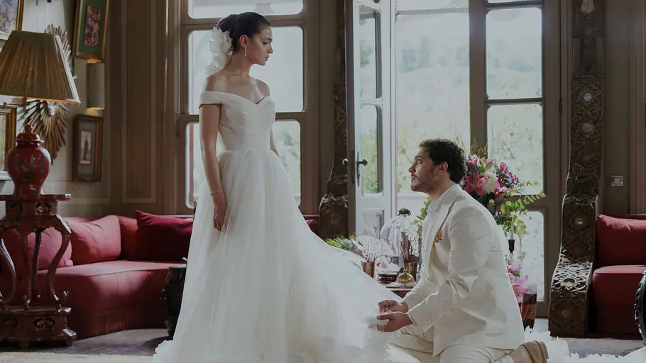 Peyami kniet vor Esvet im Hochzeitskleid.