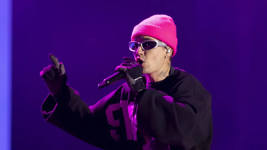 Justin Bieber Justin Bieber steht mit knallpinker Mütze und Sonnenbrille auf der Bühne