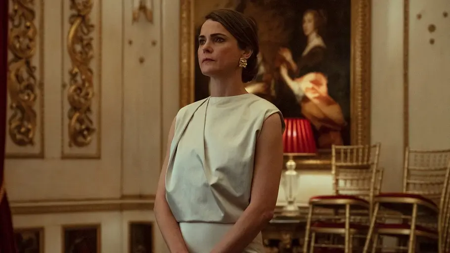 Keri Russell als US-Diplomatin Kate Wyler in „Diplomatische Beziehungen“ steht angespannt und in formeller Kleidung in einem historischen Saal.