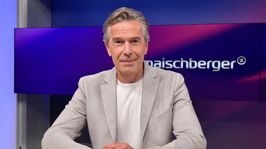 Dirk Steffens Ein Mann im hellgrauen Sakko sitzt mit gefalteten Händen an einem Tisch. Hinter ihm steht „maischberger“ auf einem Bildschirm.