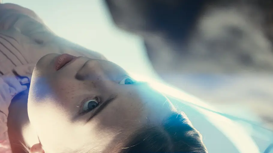 Ein Alien steht über einem jungen Kind in Disclosure Day