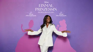 Motsi Mabuse vor dem Logo von Disney. - Foto: Disney