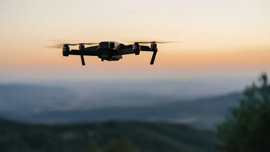 DJI Mini 5 Pro Eine Drohne fliegt am Horizont bei Sonnenuntergang