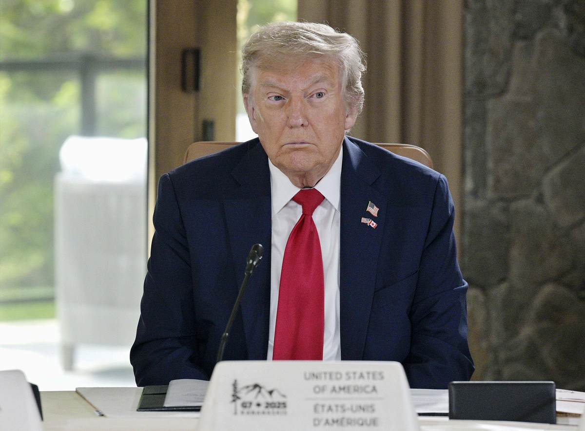 Donald Trump Smartphone T1 Donald Trump sitzt mit angestrengtem Blick an einem Tisch.