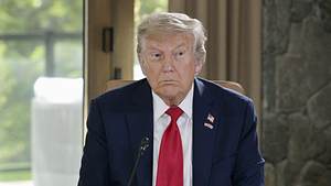 Donald Trump sitzt mit angestrengtem Blick an einem Tisch. - Foto: IMAGO / Kyodo News