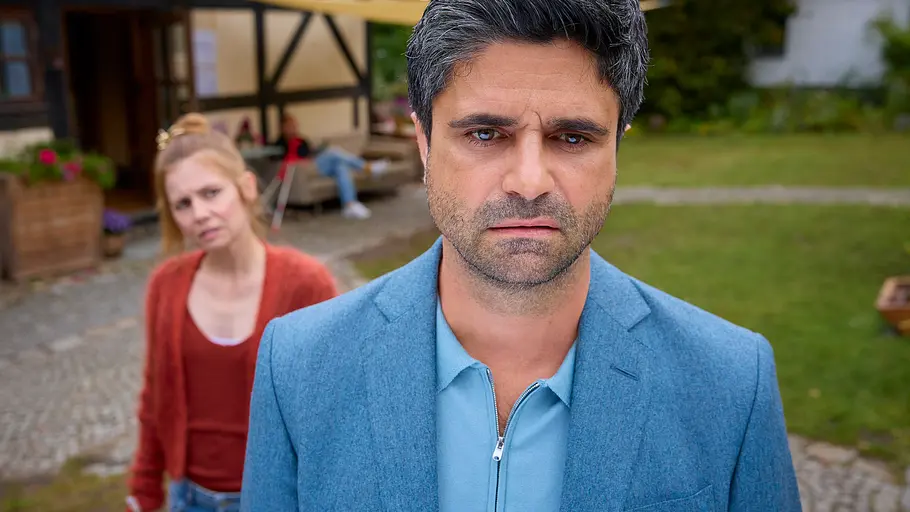Dr. Nice: „Neben der Spur“ Dr. Florian Schmidtke (Maximilian Grill) steht mit verwirrten Blick im Garten der Praxis. Hinter ihm steht Charlie (Josefine Preuß) und schaut besorgt zu ihm.