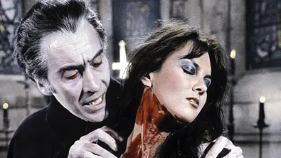 Christopher Lee schaut sich als Dracula den blutverschmierten Hals einer Frau an. - Foto: IMAGO / ZUMA Press Wire