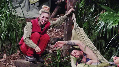 Ariel lacht und hockt neben Umuts „Bett“. Dieser schläft tief. - Foto: RTL